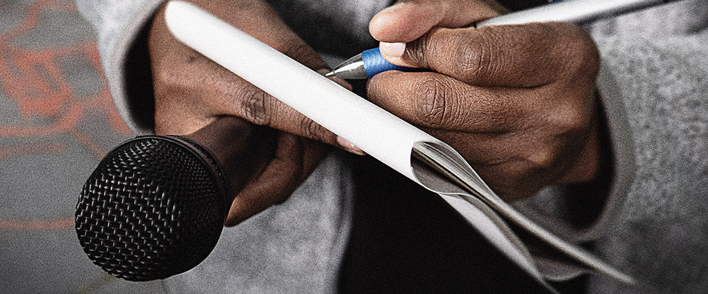 person holding writing pad and microphone